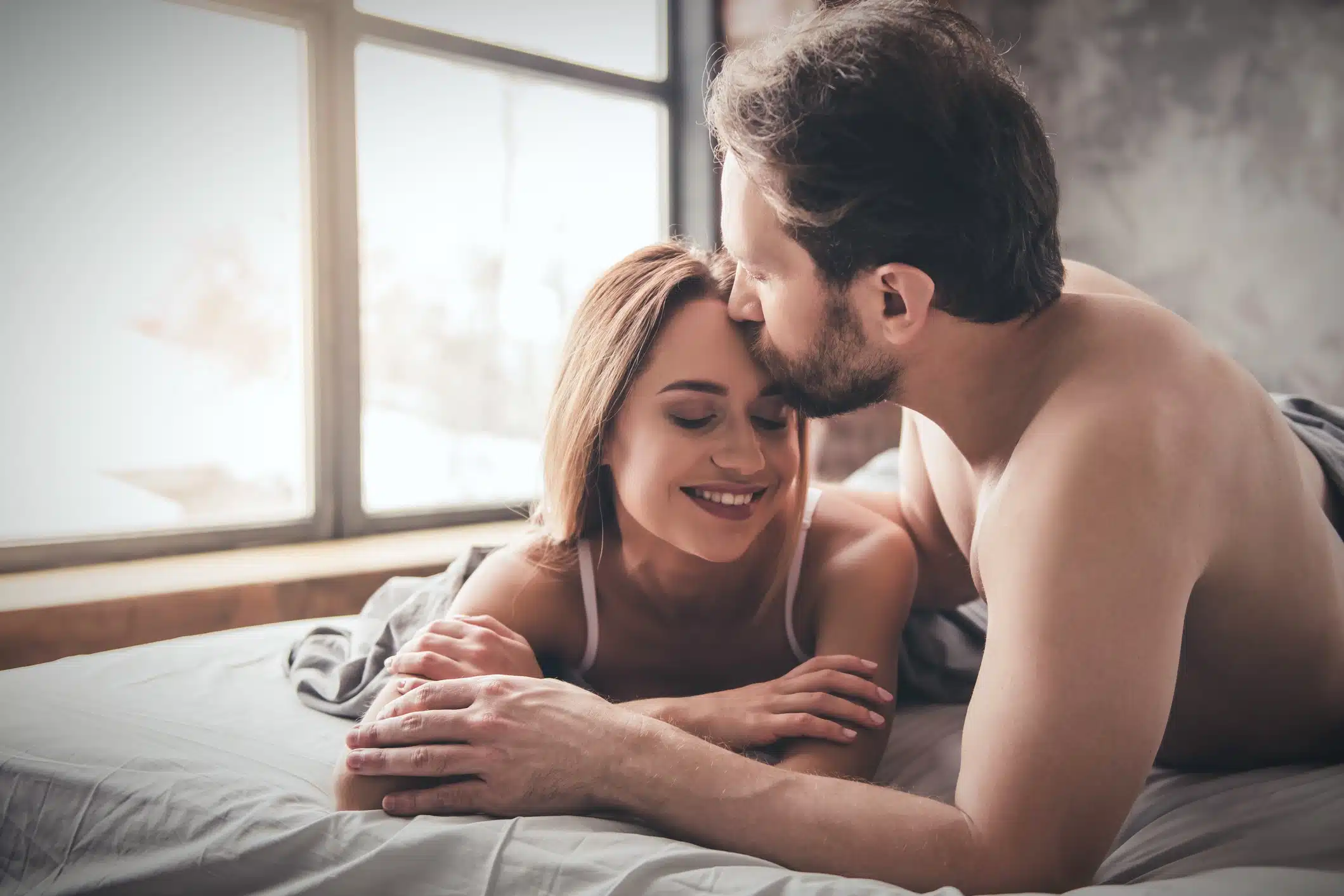 Rapports sexuels - couple heureux au lit